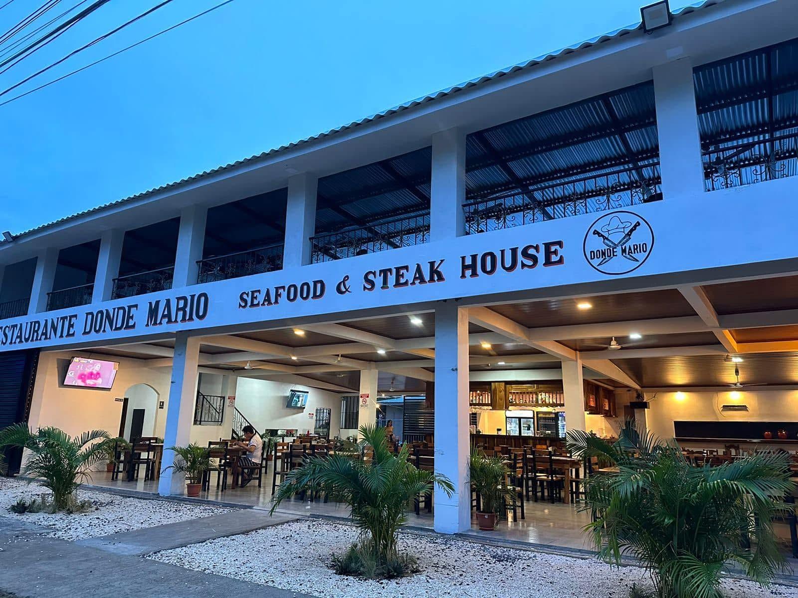 Fachada de Restaurante Donde Mario, Seafood & Steak House, iluminada al anochecer en Sardinal